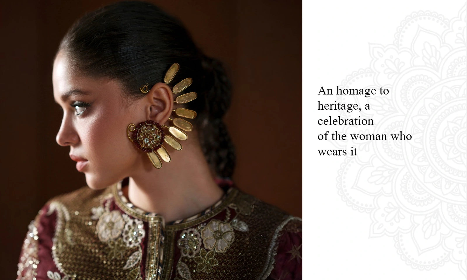 A woman in profile wearing a large ornate gold and brown earring with a decorative gold headpiece, paired with a heavily embroidered maroon and gold traditional top. The image is split into two sections: a dark portrait on the left and a white panel on the right with the text 'An homage to heritage, a celebration of the woman who wears it' and a faint mandala design.